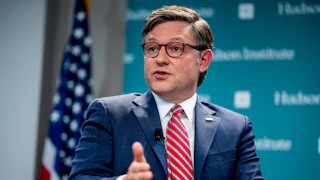 Mike Johnson, seated, speaks and makes a hand gesture in front of Hudson Institute backdrop.