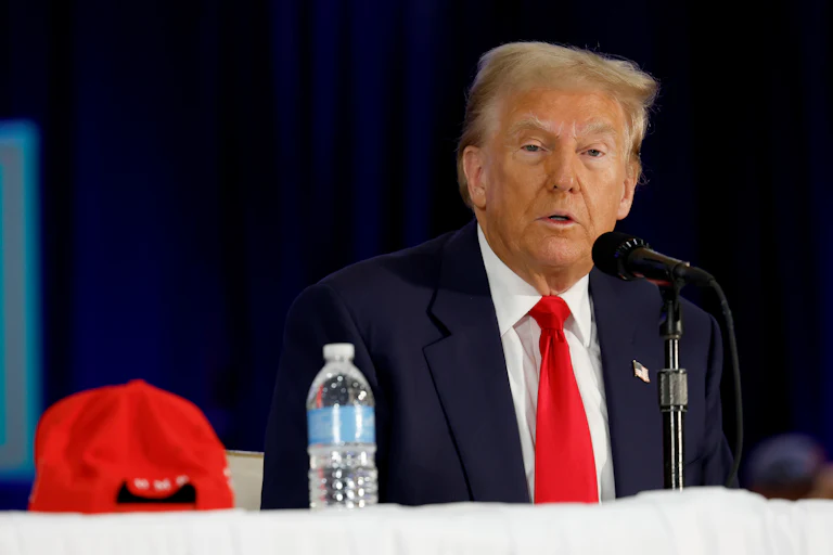 Donald Trump looks confused as he speaks at a mic