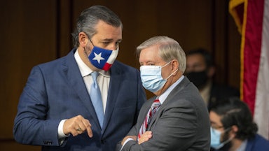 A masked Ted Cruz and Lindsey Graham have a discussion on Capitol Hill.