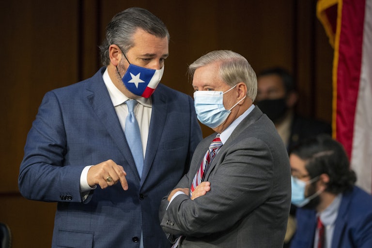 A masked Ted Cruz and Lindsey Graham have a discussion on Capitol Hill.