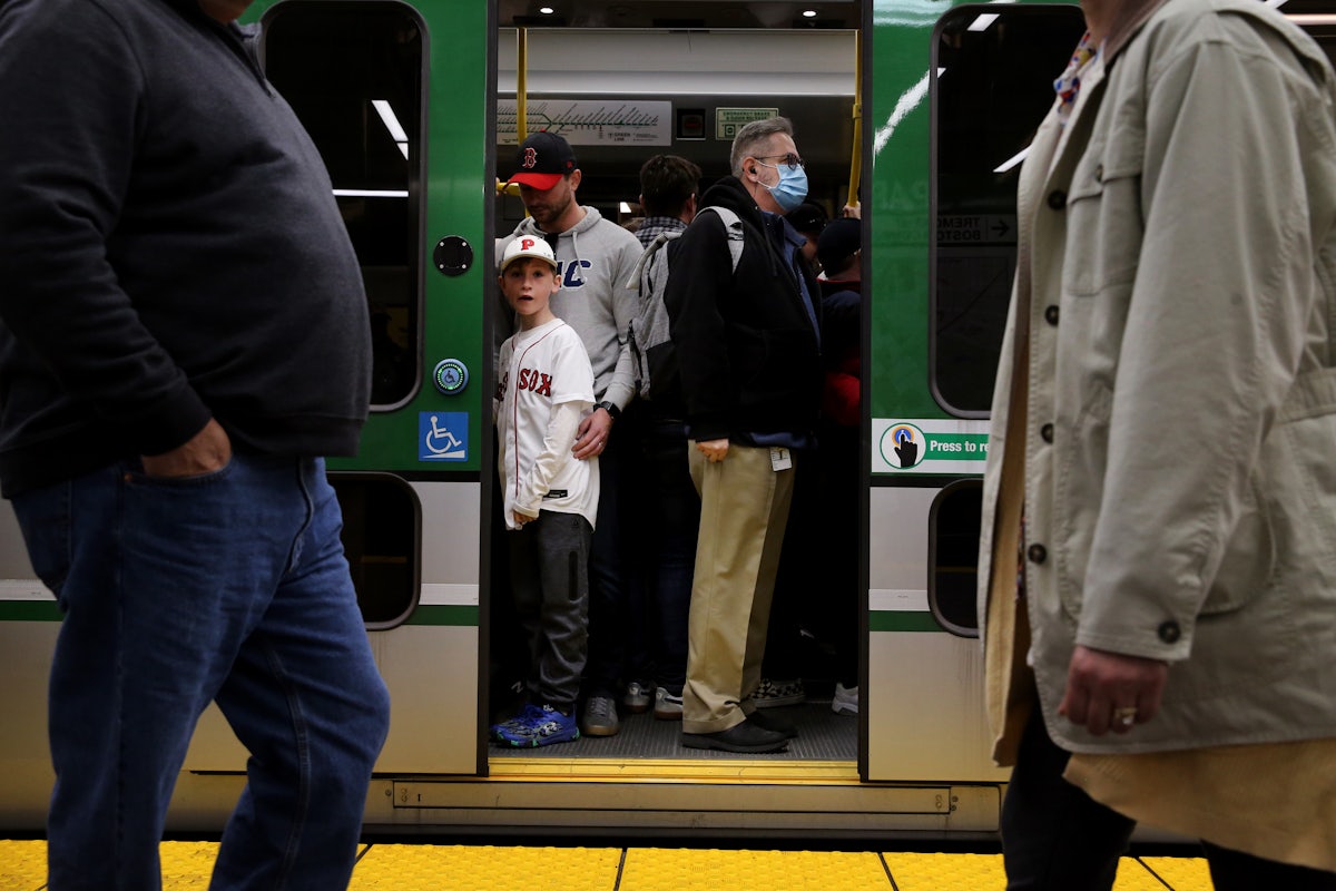 Passengers both masked and unmasked board a Green Line train.