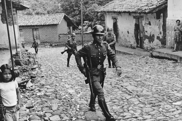 Government militia patrol a village in El Salvador during the civil war.