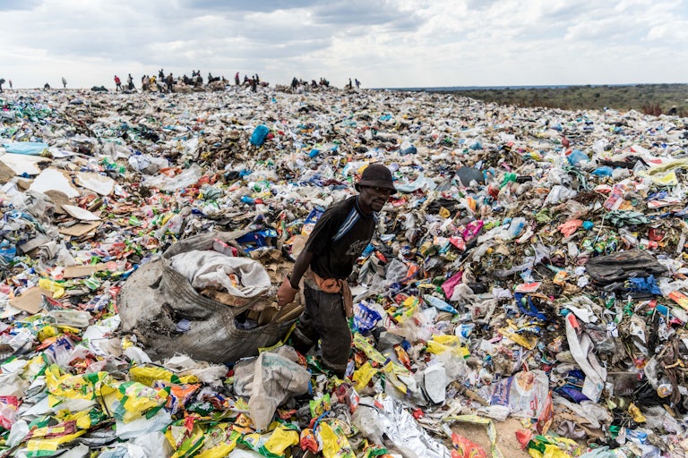 A man wades through a landfill in Bulawayo, Zimbabwe.