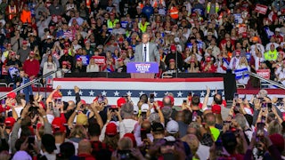 RFK Jr. stands at a podium surrounded by fans.
