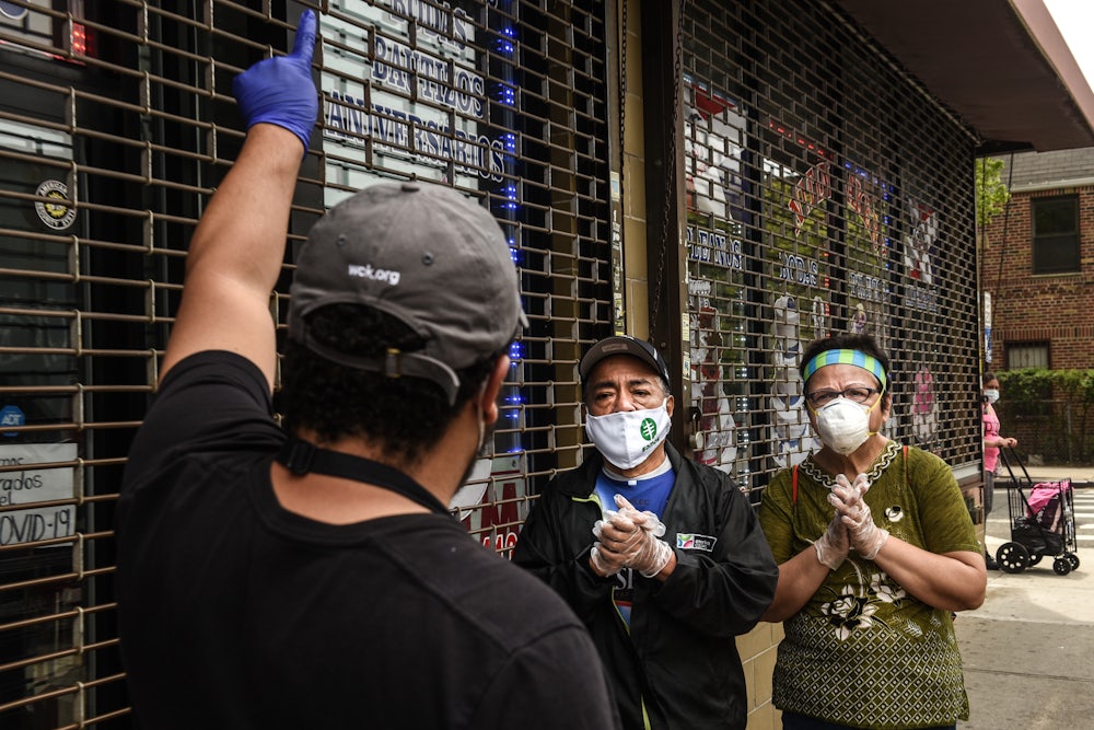 A worker wearing gloves and a Covid mask must turn away two people waiting in line to receive food from a community pantry.