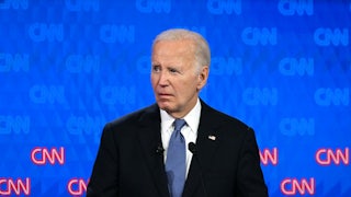 Joe Biden looks to his right on a debate stage, with a grimace on his face.