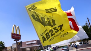 Flags in support of the FAST Recovery Act are flown at a rally of fast food workers and supporters outside a McDonalds in the Boyle Heights neighborhood of Los Angeles, California.