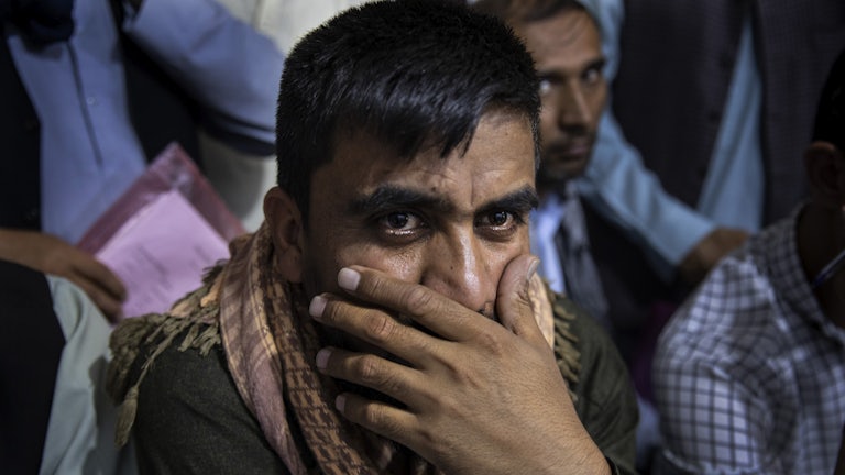 A close-up of an Afghani man, seeking an immigration application.