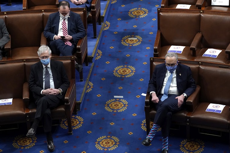 A masked Mitch McConnell sits across the aisle from a masked Chuck Schumer in a nearly empty Senate.