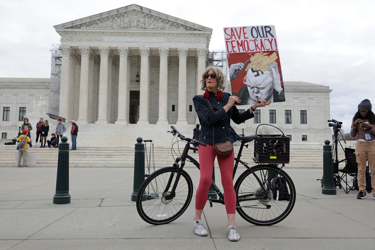 Local resident Nicky Sundt holds a sign that read “Save Our Democracy” in front of the Supreme Court, which unanimously ruled to keep former U.S. President Donald Trump on the Colorado ballot.