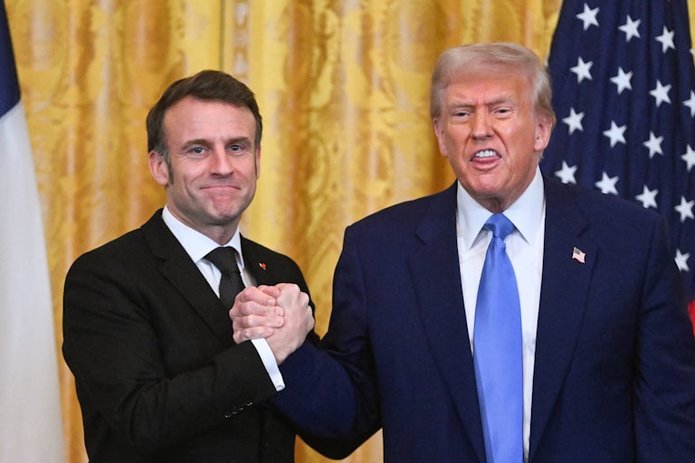 French President Emmanuel Macron and Donald Trump clasp hands during a joint press conference