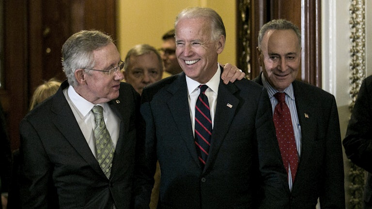 Senators Harry Reid and Chuck Schumer leave the Senate chamber with a beaming Vice President Biden in 2012 