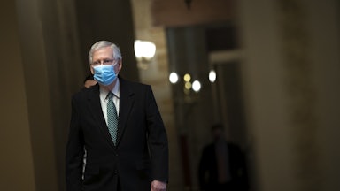 Minority Leader Mitch McConnell walks to the Senate Chamber wearing a mask.