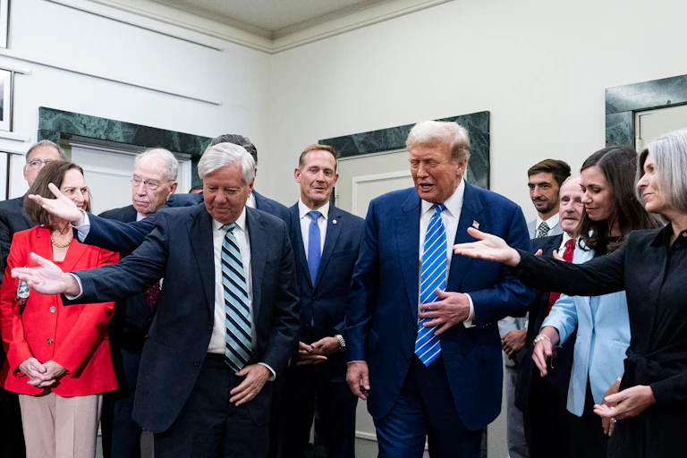 Donald Trump is in the center of the photo, as Republican senators including Lindsey Graham surround him and all extend a hand as if to let Trump walk first.