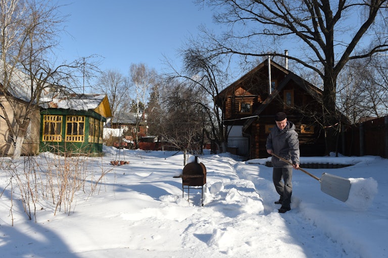 A man shovels snow outside his home