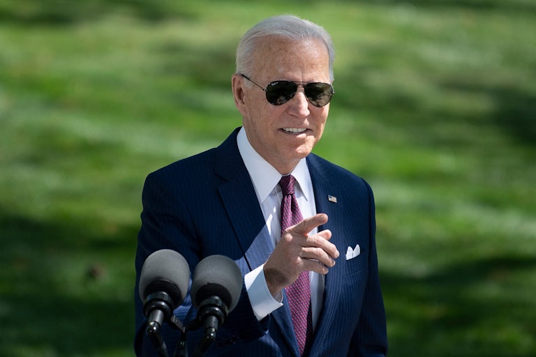 Joe Biden, wearing sunglasses, gestures.