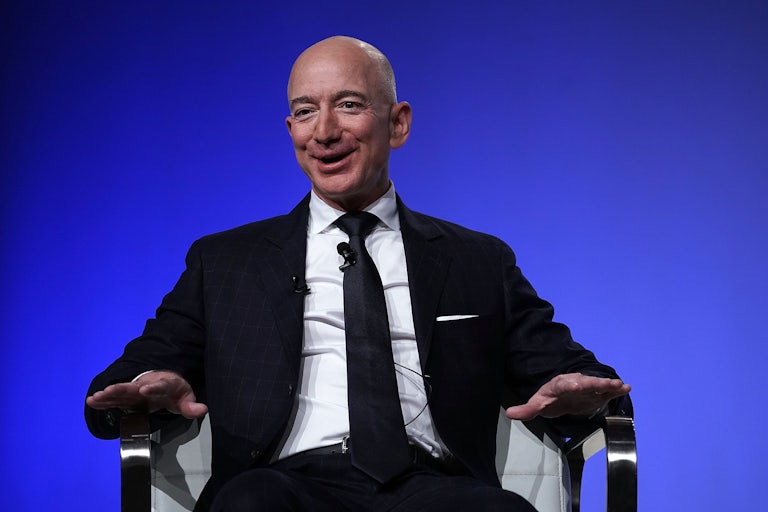 A smiling Jeff Bezos sits in a chair.