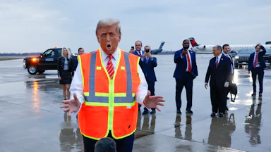 Donald Trump gestures while speaking to reporters