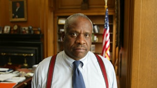 Supreme Court Justice Clarence Thomas stands in his office.