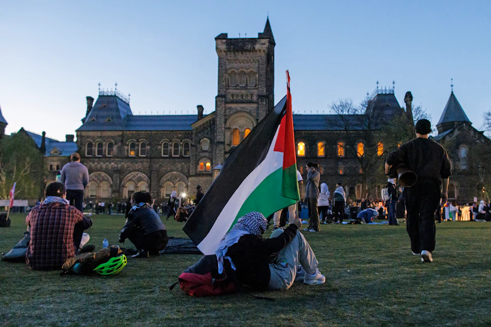 A demonstrator holds a Palestinian flag at a pro-Palestine encampment at the University of Toronto
