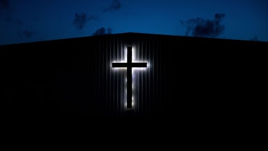 An illuminated cross on a church