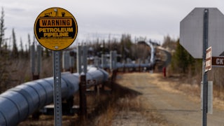 An oil pipeline snakes through a landscape.