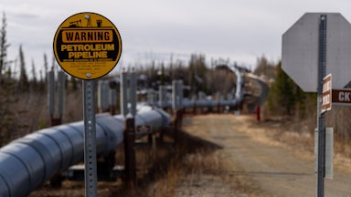 An oil pipeline snakes through a landscape.