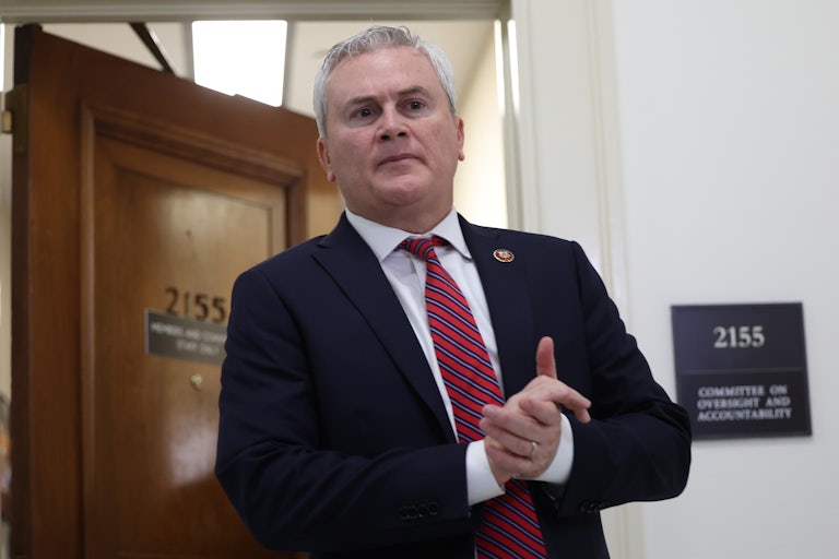 James Comer clasps his hands together as he exits a room