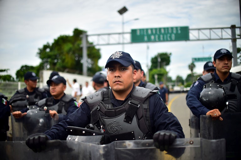 Mexican Federal Police officers get ready for the arrival of a caravan of Honduran migrants heading to the U.S.