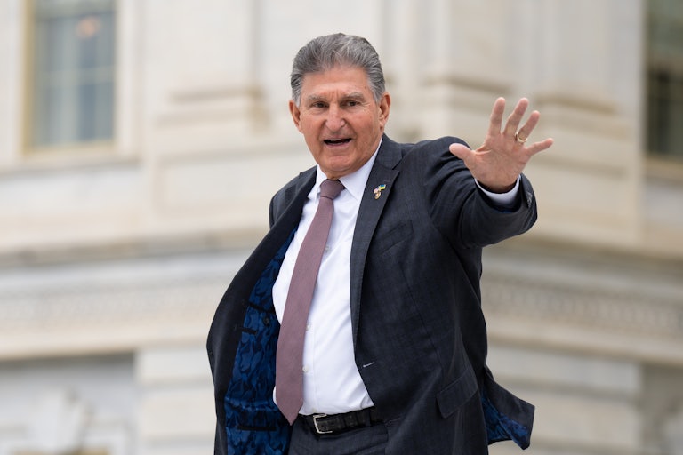 Joe Manchin waves from the steps of the Capitol.
