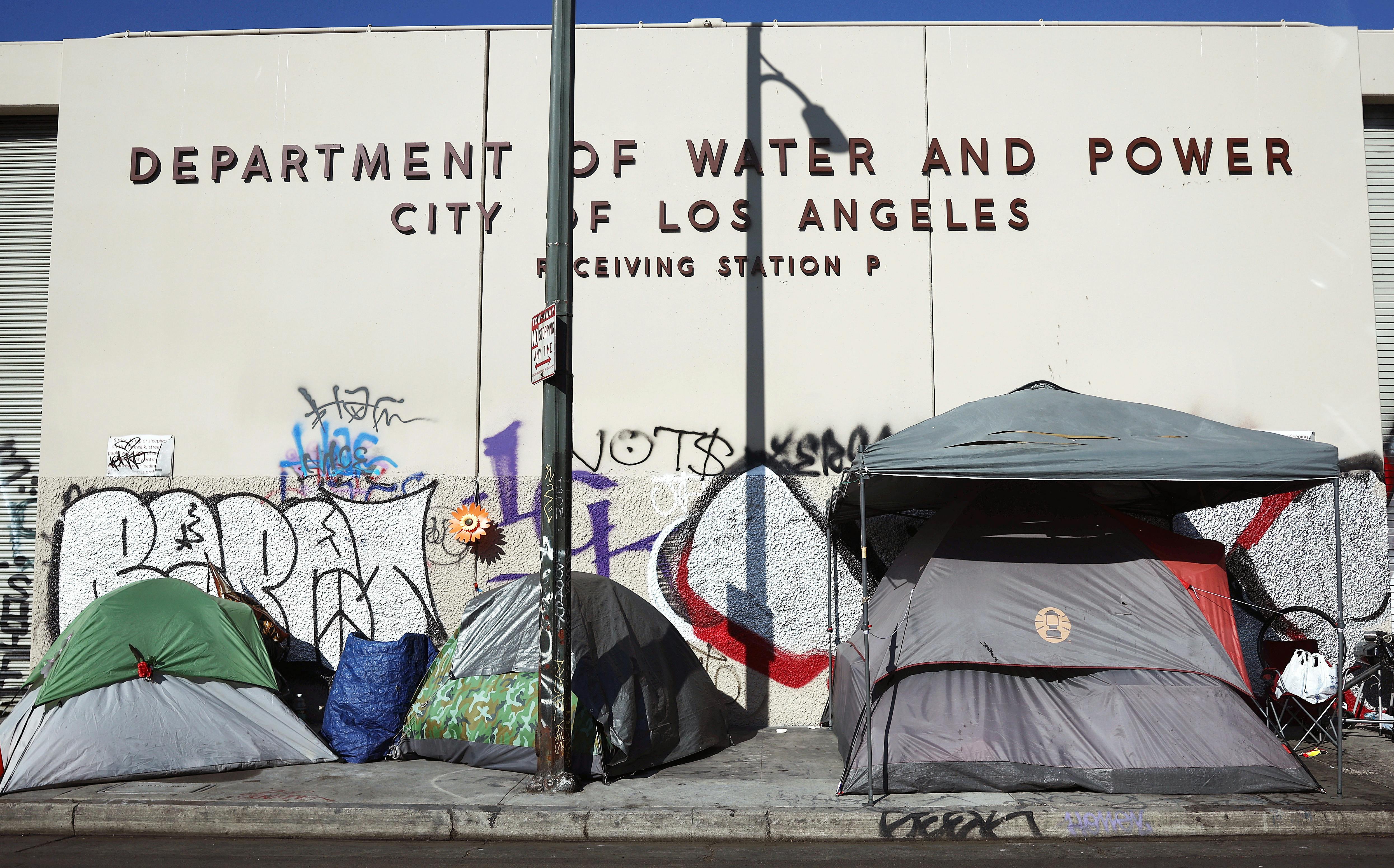 A homeless encampment stands in front of a city water and power building in the Skid Row community in Los Angeles, California. 