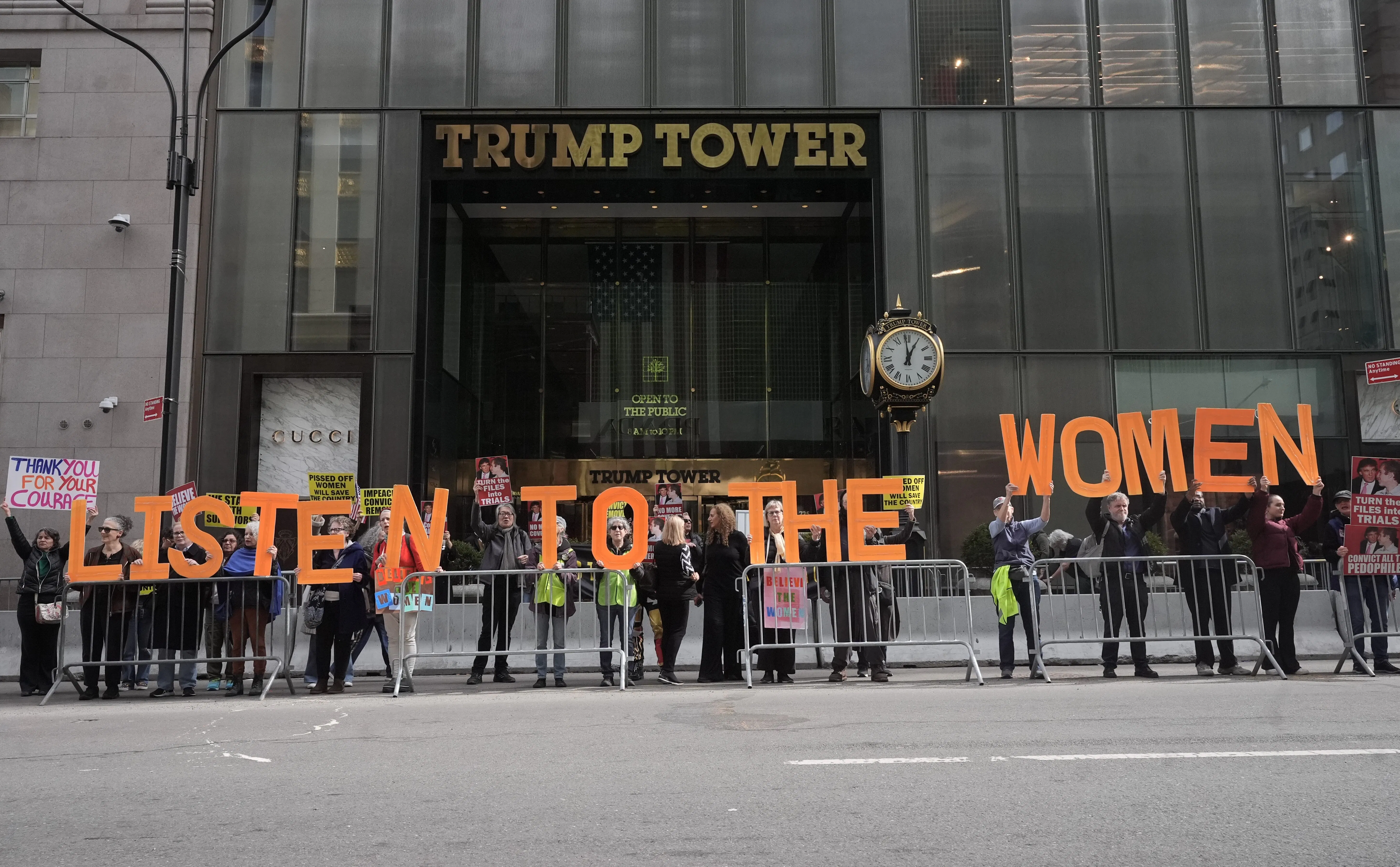 People hold up letters that spell out "Listen to the women" during a protest outside Trump Tower in New York City