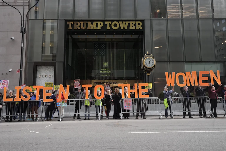 People hold up letters that spell out "Listen to the women" during a protest outside Trump Tower in New York City