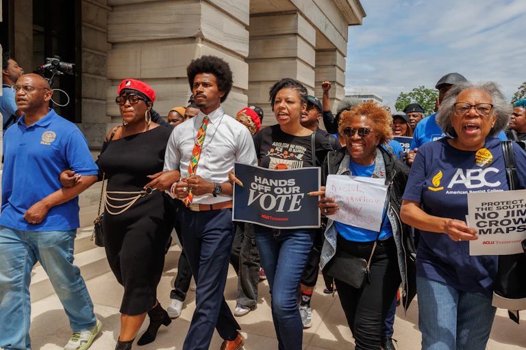 Democratic state Representative Justin Pearson leads a march of demonstrators holding signs like "Hands Off Our Vote."