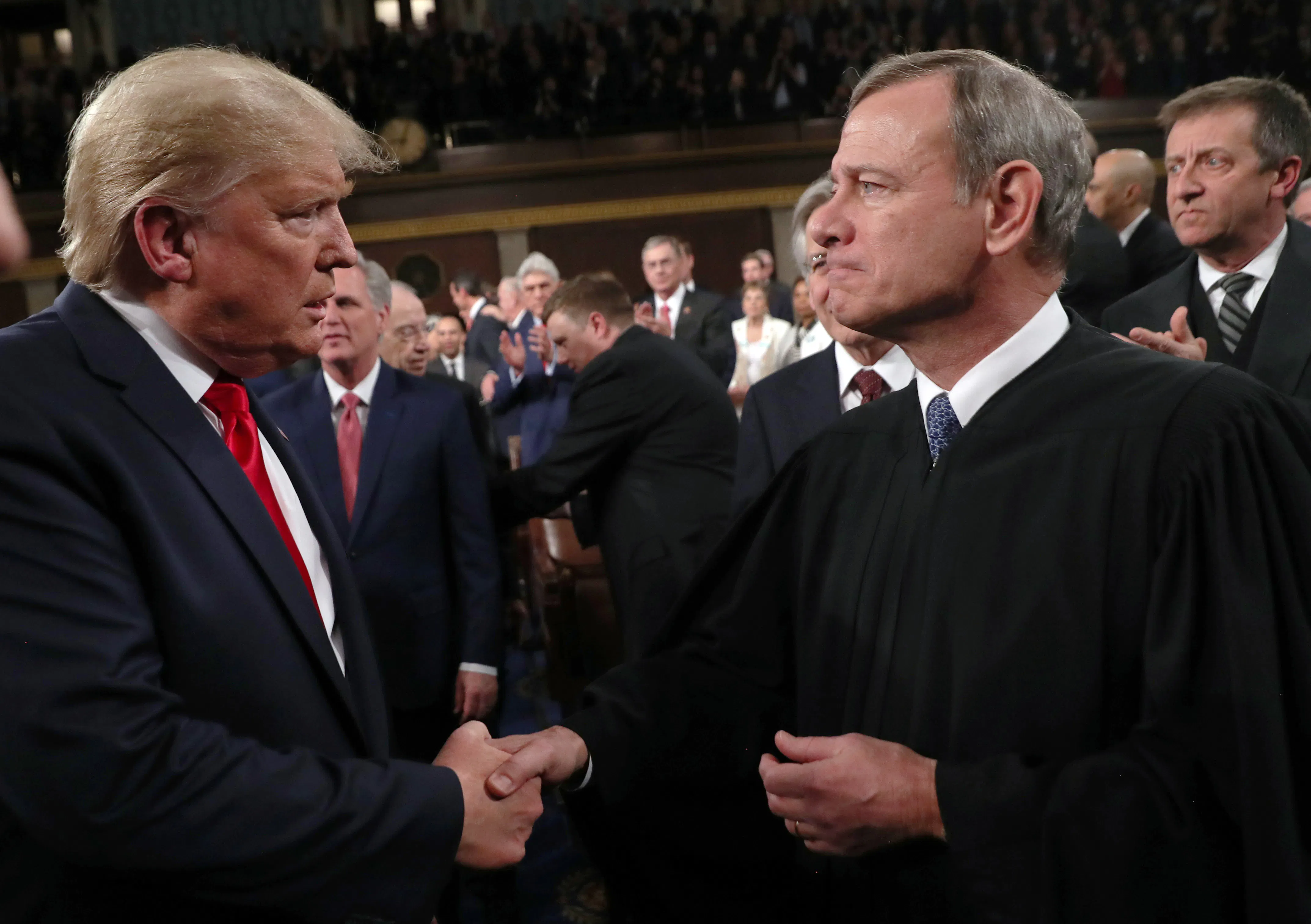 Donald Trump shakes hands with Supreme Court Chief Justice John Roberts.