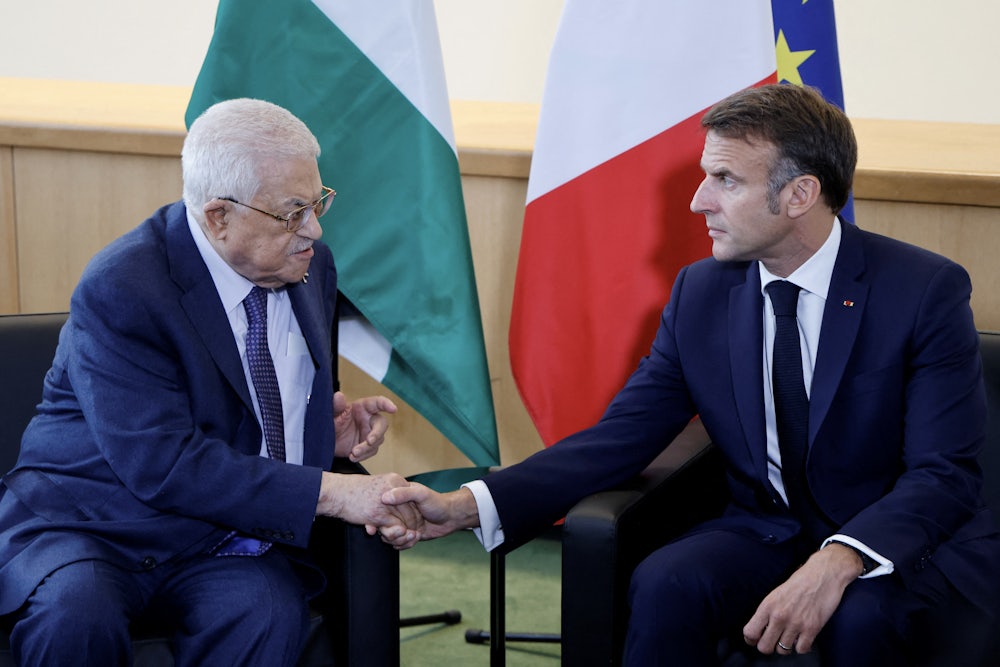 French President Emmanuel Macron (R) shakes hands with Palestinian President Mahmud Abbas