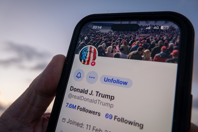 A phone screen shows Donald Trump’s Truth Social account