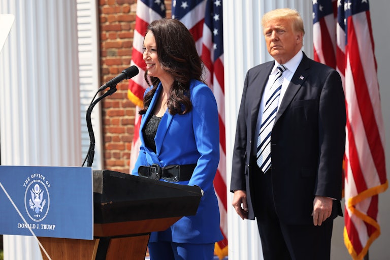Agriculture Secretary Brooke Rollins speaks at a podium while Donald Trump stands behind her