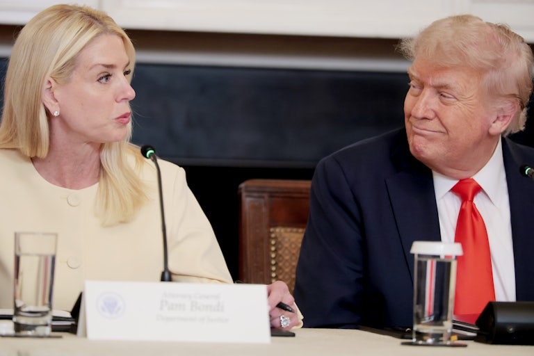 Attorney General Pam Bondi speaks while seated next to Donald Trump