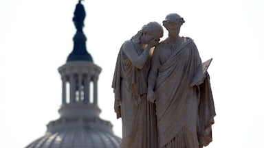 Statues depicting Grief and History stand watch over the U.S. Capitol.