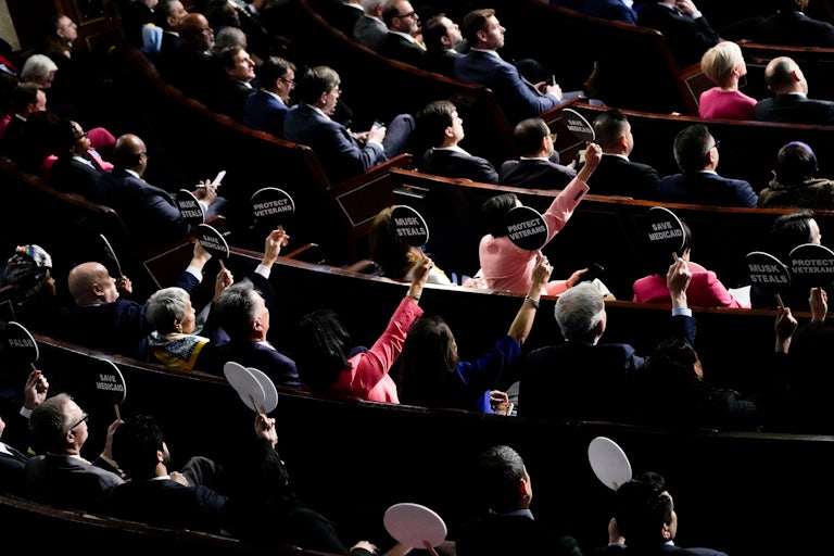 Democrats hold up signs in protest during Donald Trump’s speech to a joint session of Congress
