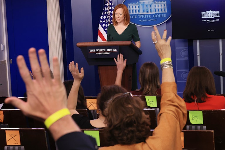Members of the press raise their hands as Jen Psaki conducts a news conference.