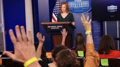 Members of the press raise their hands as Jen Psaki conducts a news conference.