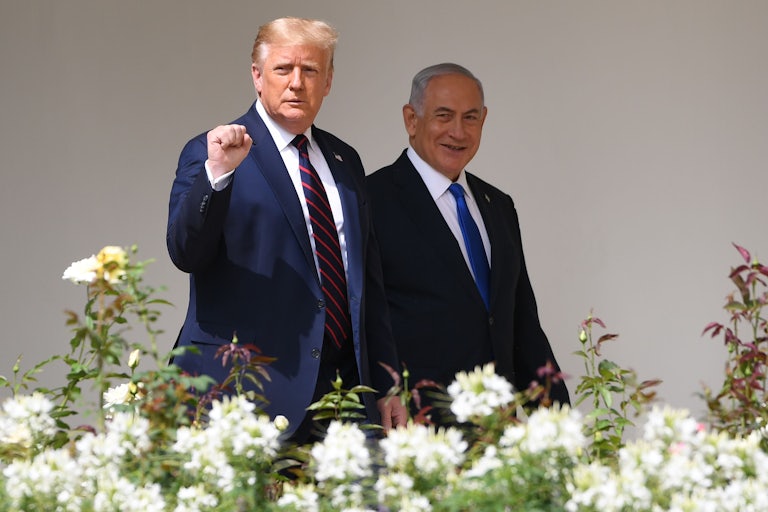 Donald Trump holds up a fist as he walks with Benjamin Netanyahu at the White House