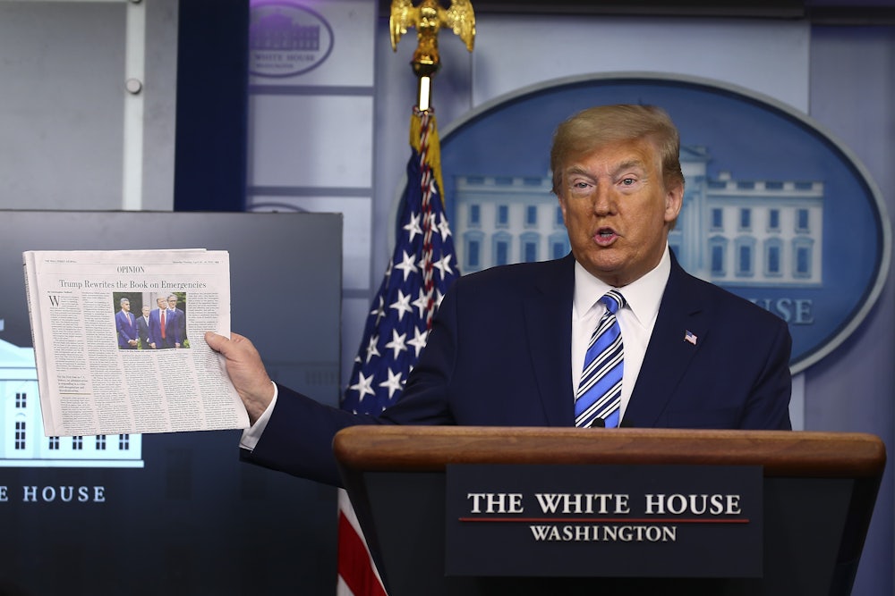 President Donald Trump holds up The Wall Street Journal during a coronavirus briefing