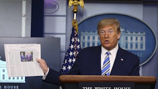 President Donald Trump holds up The Wall Street Journal during a coronavirus briefing