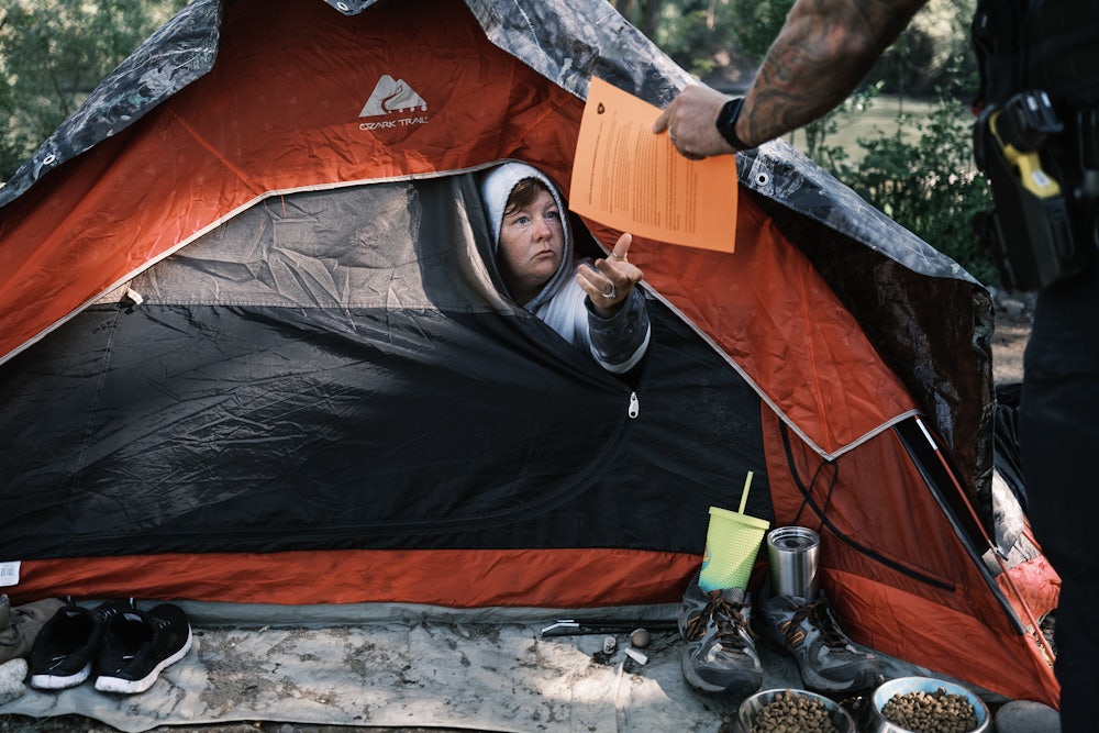 Officer Tim Artoff handed Terry Goodloe an order to vacate at Baker Park in Grants Pass, Oregon, in April 2024.