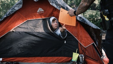 Officer Tim Artoff handed Terry Goodloe an order to vacate at Baker Park in Grants Pass, Oregon, in April 2024.