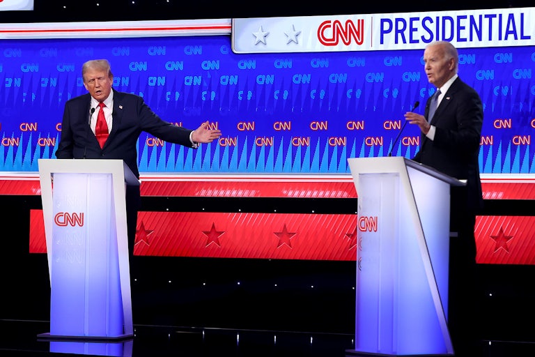 Donald Trump and Joe Biden both speak and make hand gestures on CNN debate stage.