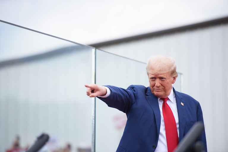 Donald Trump smiles and points